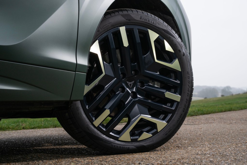 Close-up of a stylish alloy wheel with a unique design, featuring black and metallic accents, mounted on a vehicle.