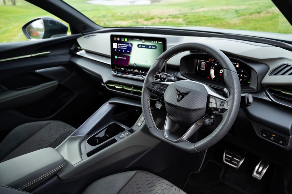 Interior view of a modern car showcasing a steering wheel, digital dashboard, and central touchscreen display.